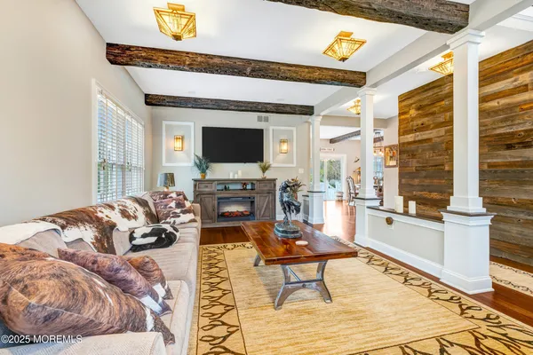 a kitchen with stainless steel appliances granite countertop a table chairs refrigerator and wooden floor