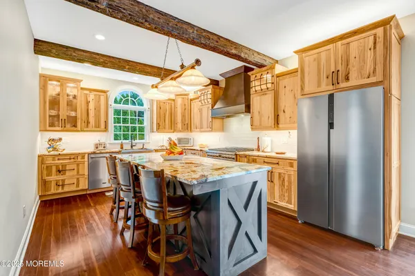 a kitchen with stainless steel appliances granite countertop a sink and a stove next to a window