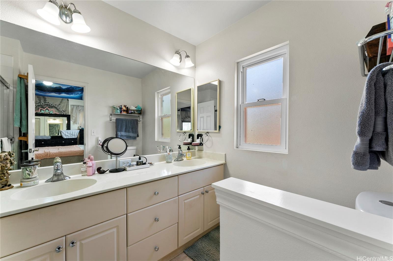 87-1962 Pakeke Street, Unit A Waianae, HI 96792 - Photo 13 of 25 a bathroom with a double vanity sink and a mirror