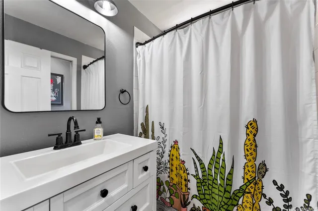 a bathroom with a sink a mirror and a shower curtain