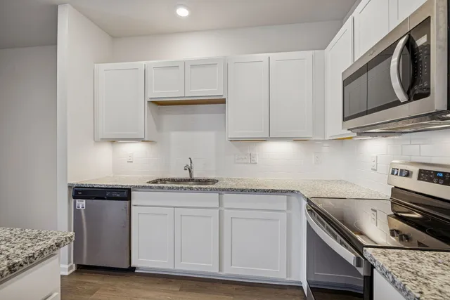 a kitchen with stainless steel appliances granite countertop a sink and a stove