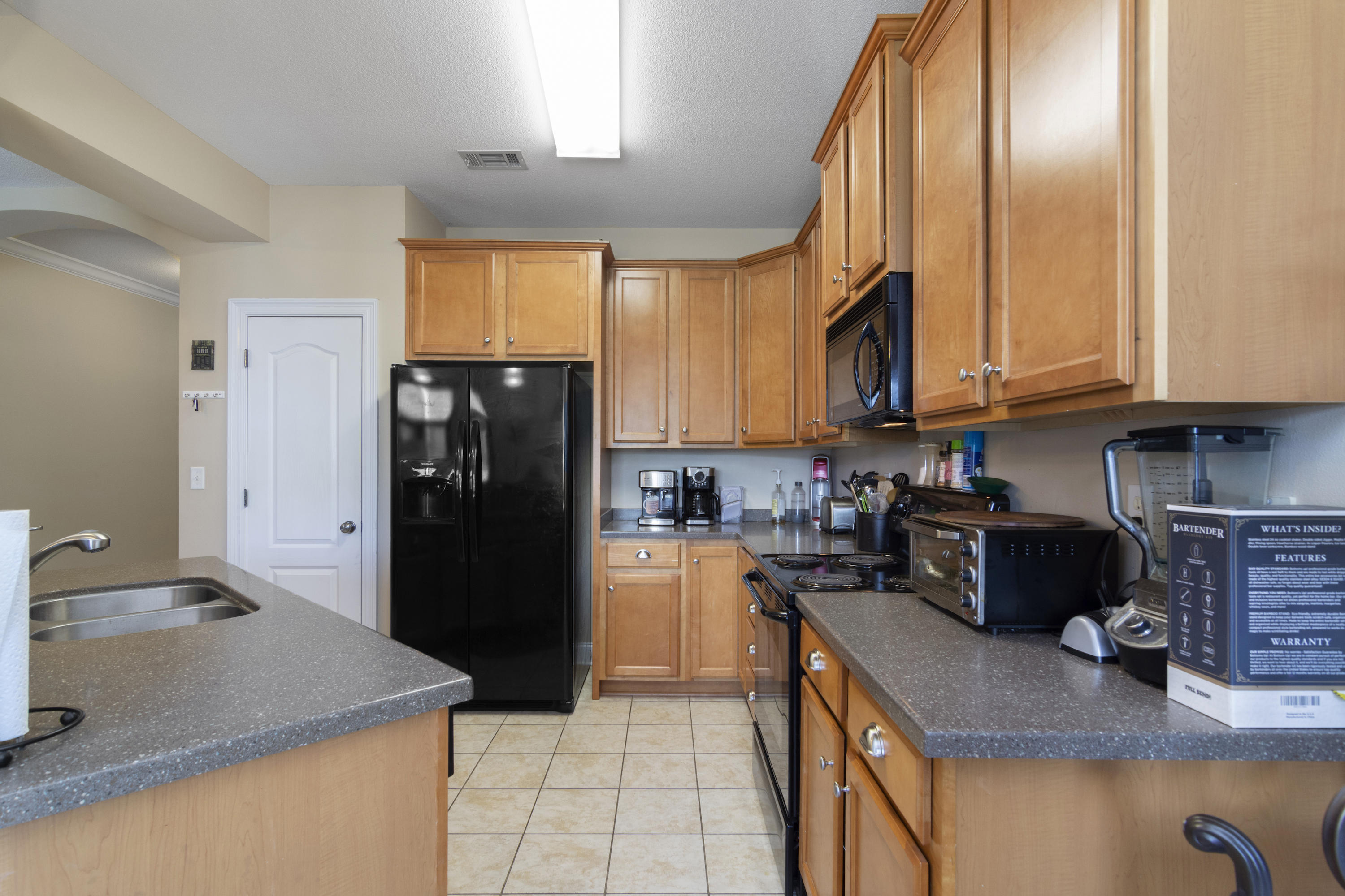 145 Alicia Drive Crestview, FL 32536 - Photo 11 of 32 a kitchen with granite countertop a refrigerator a stove and a sink