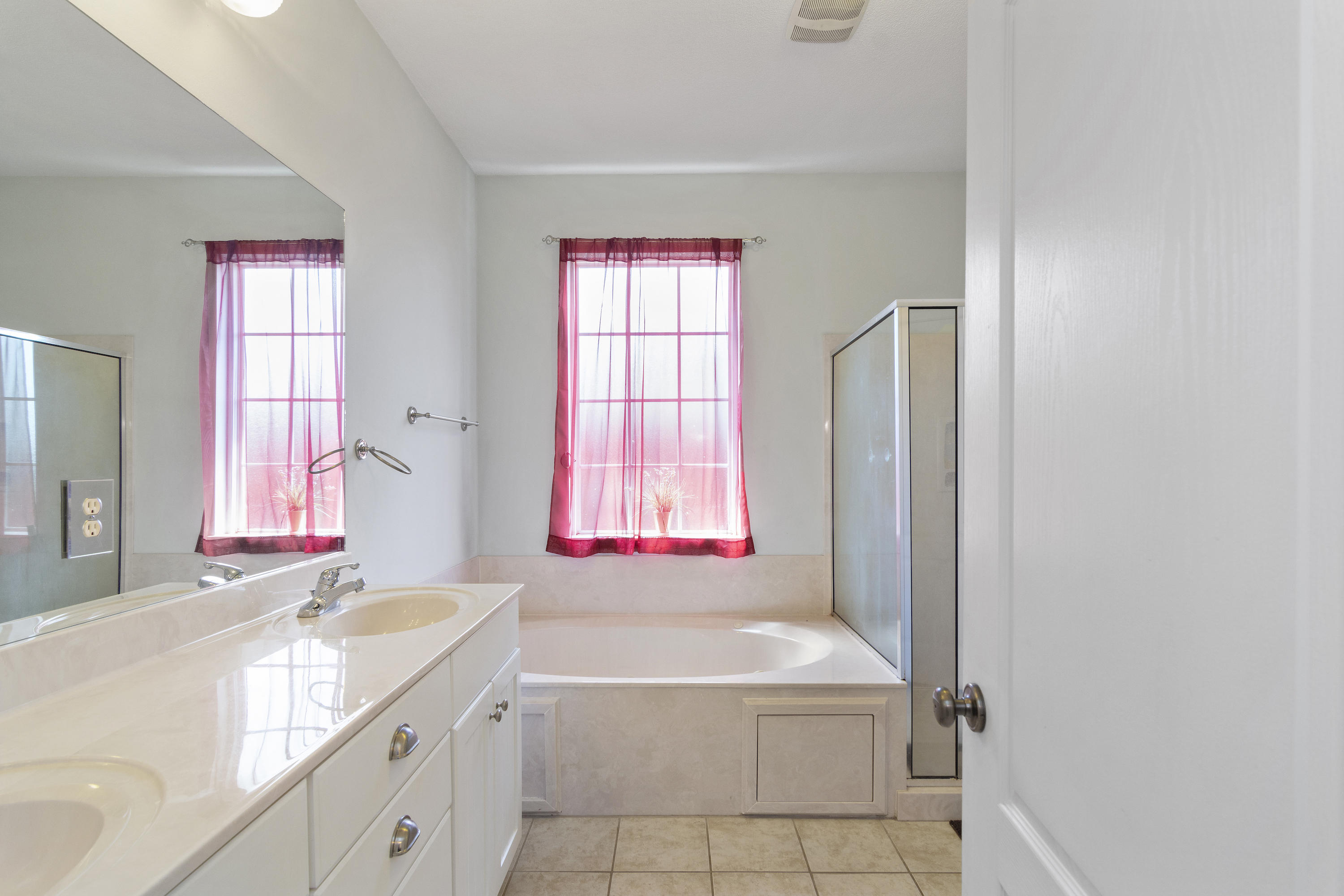 145 Alicia Drive Crestview, FL 32536 - Photo 18 of 32 a bathroom with a granite countertop tub sink a window and mirror