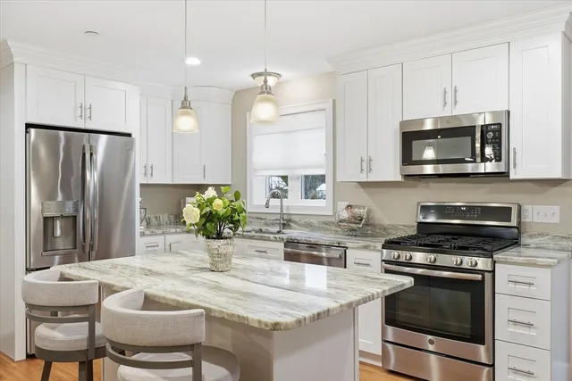 a kitchen with stainless steel appliances a stove a sink and a refrigerator