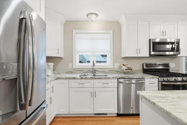 a kitchen with stainless steel appliances granite countertop a stove a sink and a refrigerator