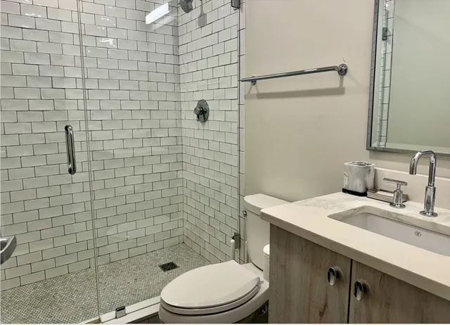 a bathroom with a sink a toilet and shower