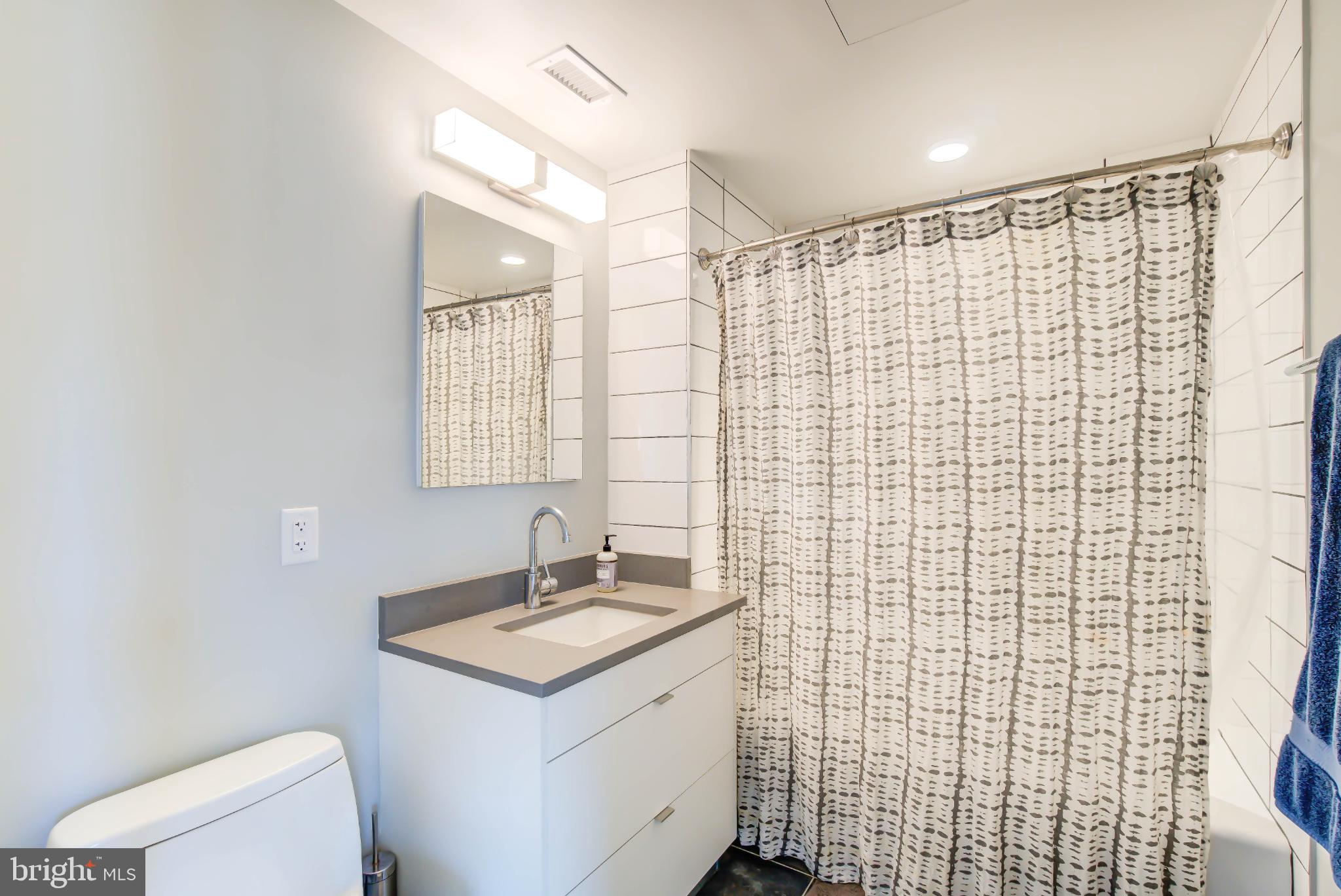1300 4th Street Southeast, Unit 414 Washington, DC 20003 - Photo 12 of 31 a bathroom with a granite countertop sink toilet and shower
