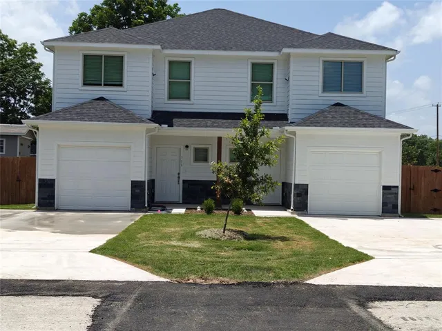 a front view of a house with a yard and garage