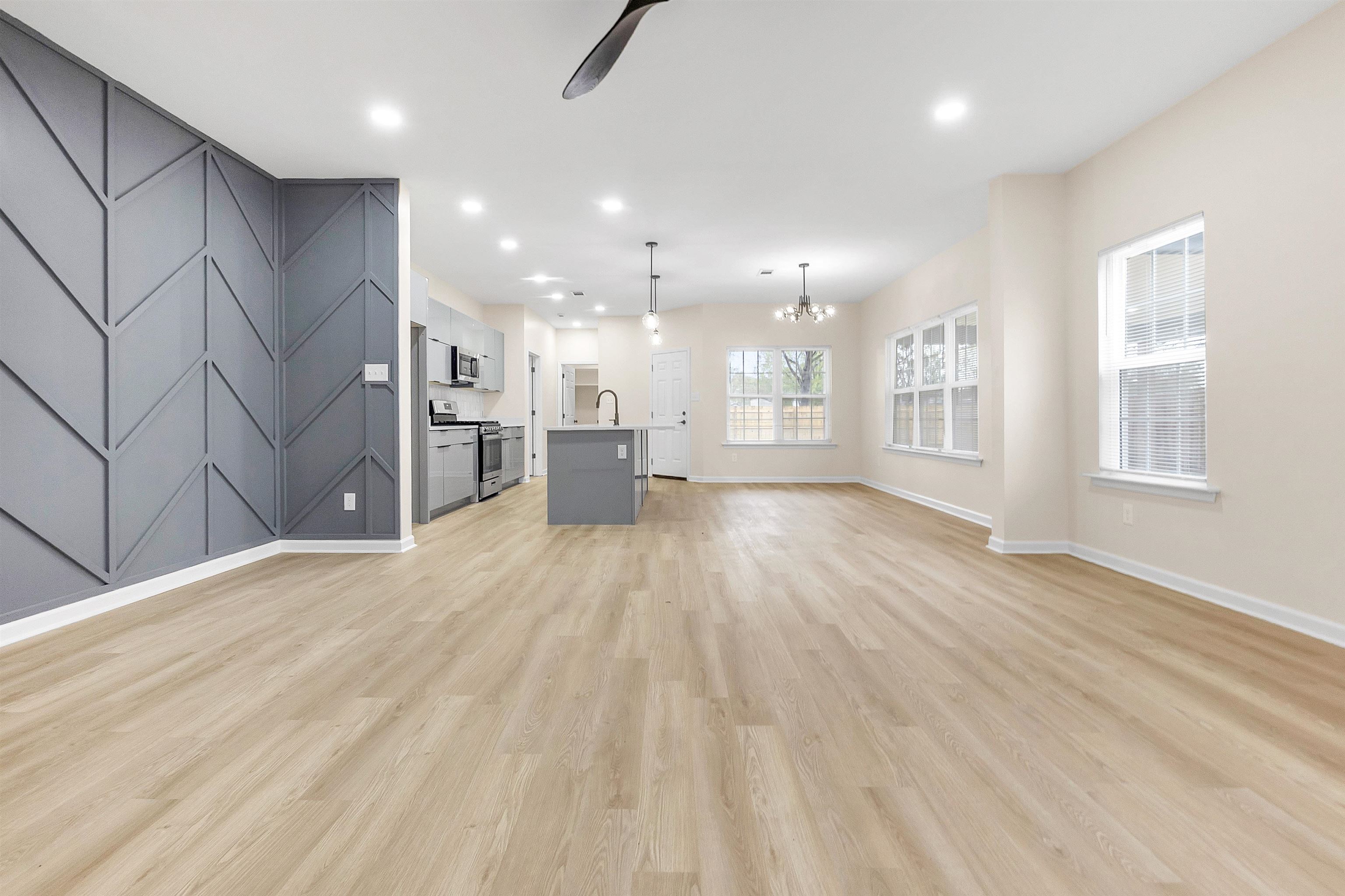 4397 Crescent Park Drive Memphis, TN 38141 - Photo 16 of 40 Unfurnished living room featuring light wood finished floors, baseboards, recessed lighting, a sink, and ceiling fan with notable chandelier