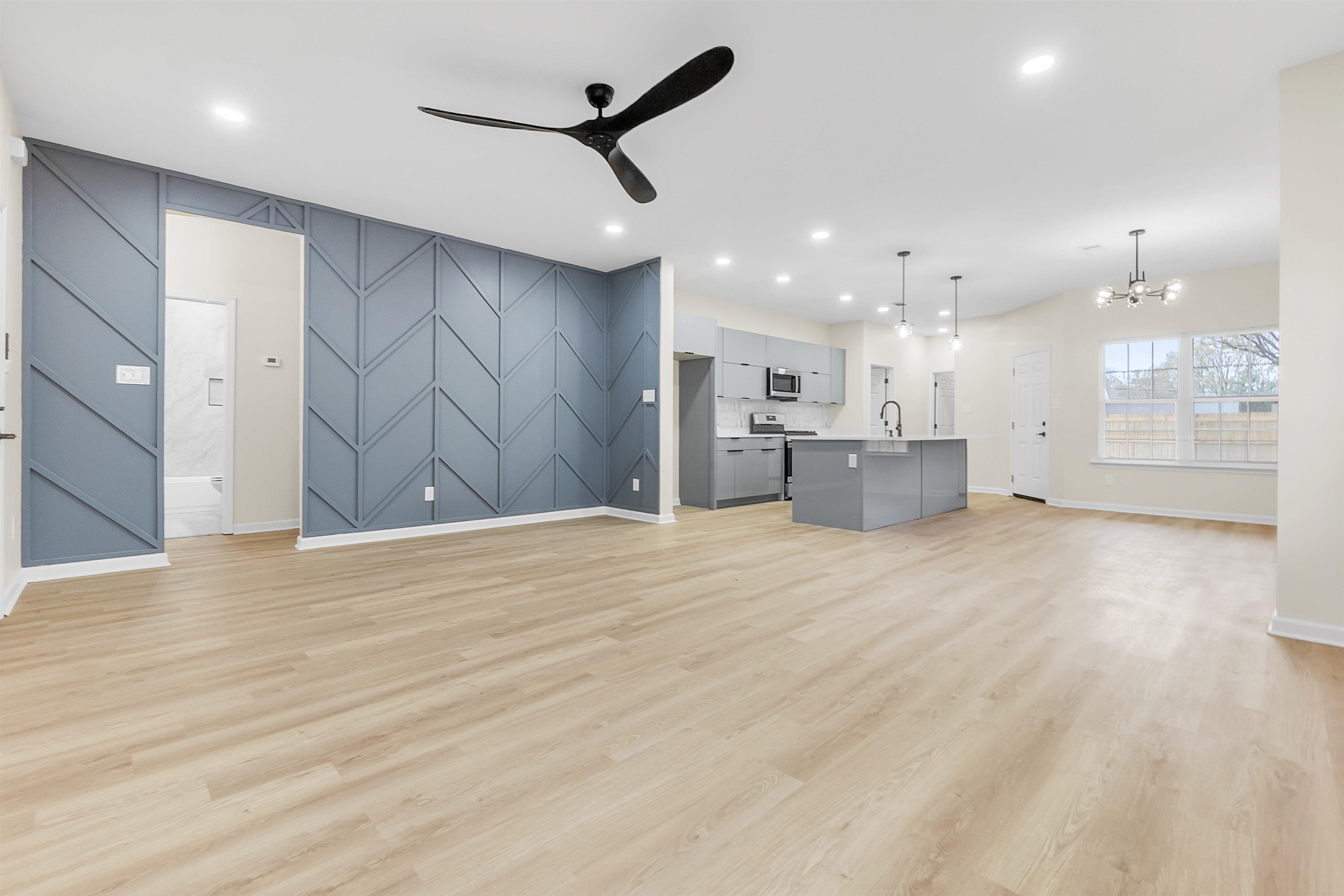 4397 Crescent Park Drive Memphis, TN 38141 - Photo 20 of 40 Unfurnished living room featuring recessed lighting, a sink, light wood-style floors, ceiling fan with notable chandelier, and an accent wall