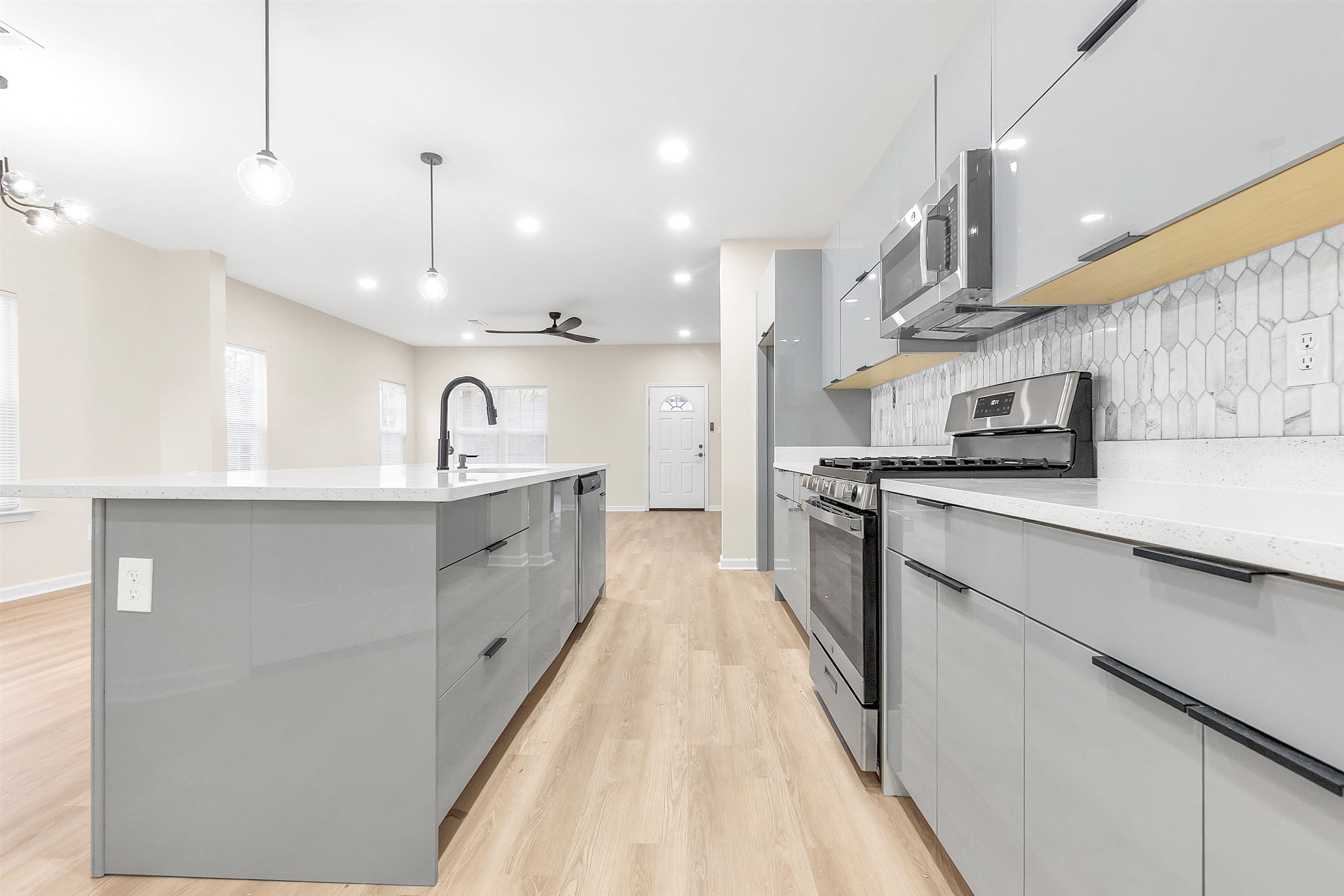4397 Crescent Park Drive Memphis, TN 38141 - Photo 6 of 40 Kitchen featuring modern cabinets, gray cabinets, tasteful backsplash, and appliances with stainless steel finishes