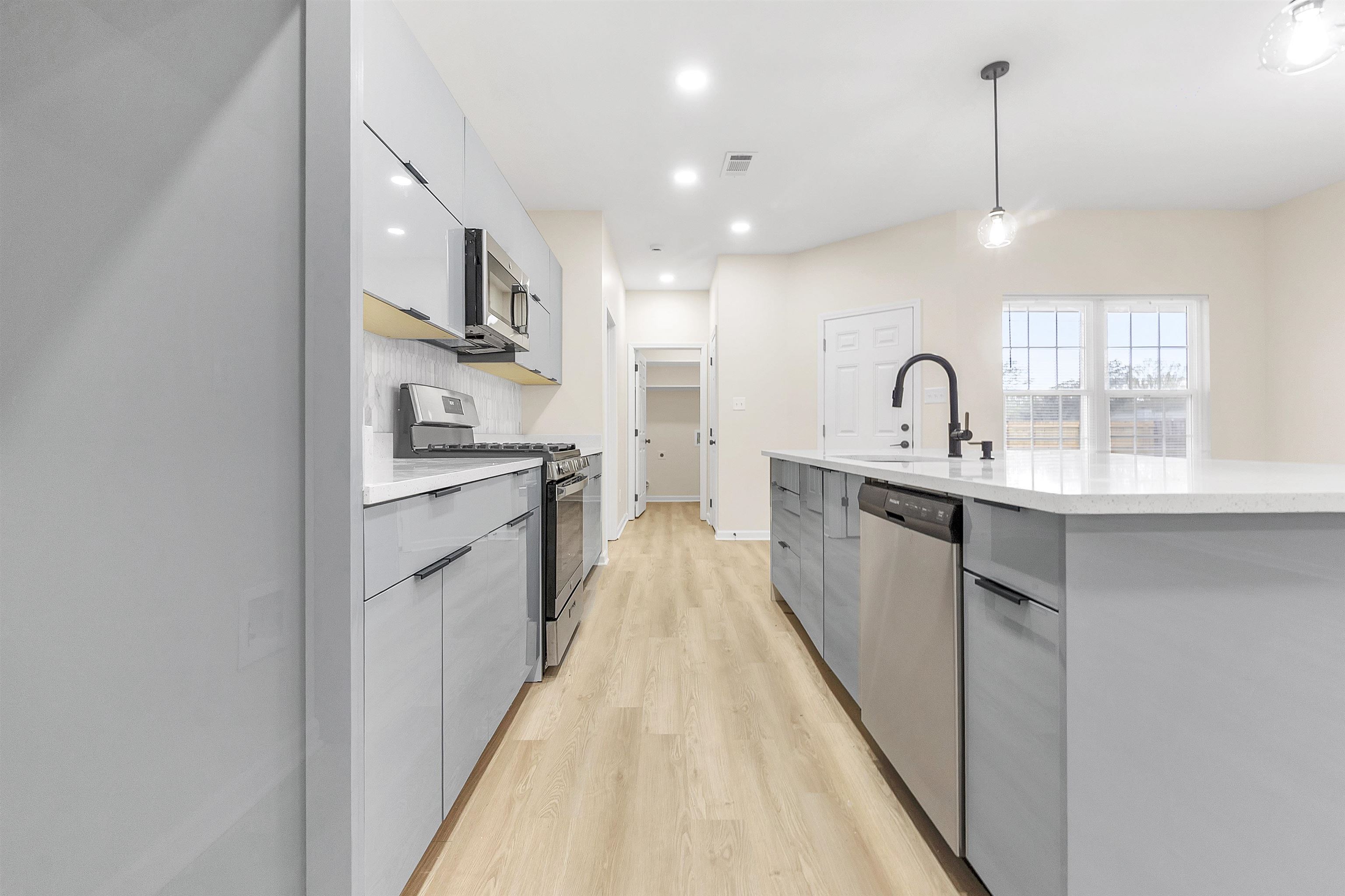 4397 Crescent Park Drive Memphis, TN 38141 - Photo 7 of 40 Kitchen with modern cabinets, a sink, light wood-style floors, and appliances with stainless steel finishes