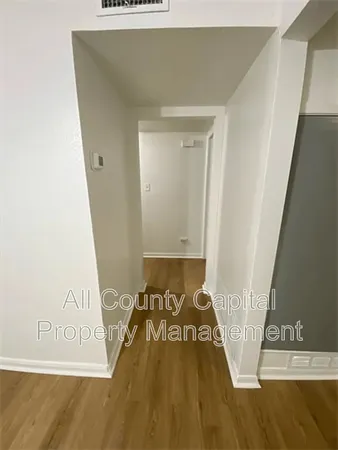 a view of a bedroom with wooden floor