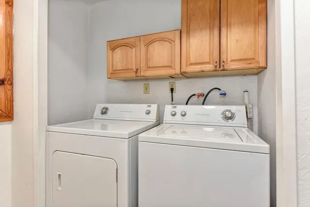 a kitchen with granite countertop white cabinets a window and wooden floor