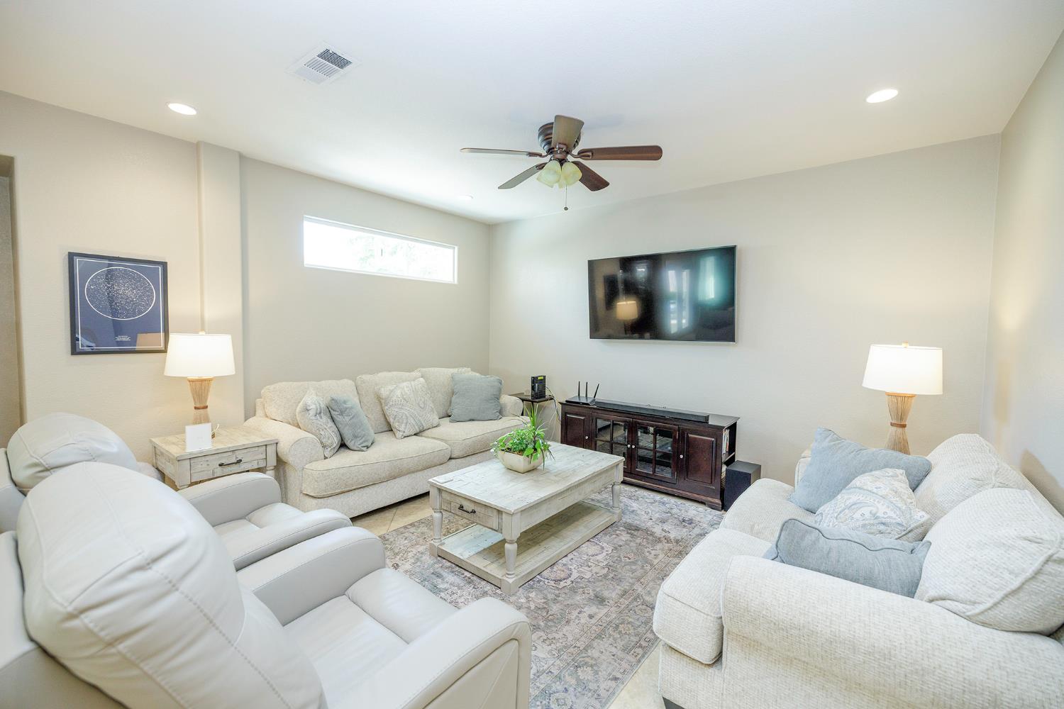 3416 Will Scarlet Way Modesto, CA 95355 - Photo 16 of 56 a living room with furniture a lamp and a flat screen tv