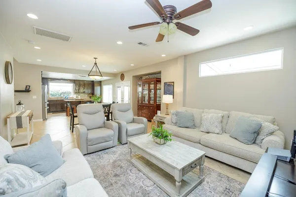 a dining hall with stainless steel appliances granite countertop a stove a sink a dining table and chairs with wooden floor