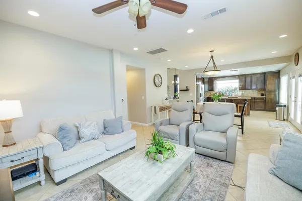 a kitchen with granite countertop a stove a sink a dining table and chairs