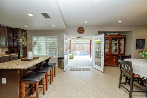 a kitchen with stainless steel appliances a table chairs refrigerator and microwave