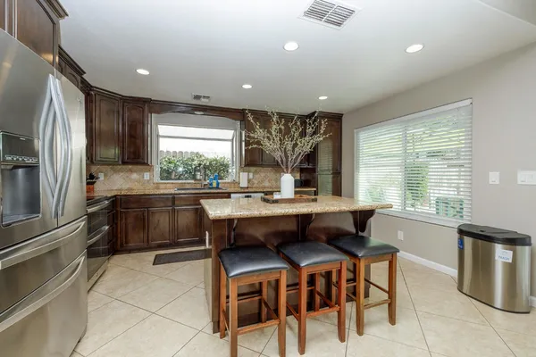a kitchen with granite countertop stainless steel appliances and refrigerator