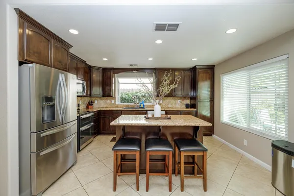 a kitchen with stainless steel appliances granite countertop a sink stove and refrigerator