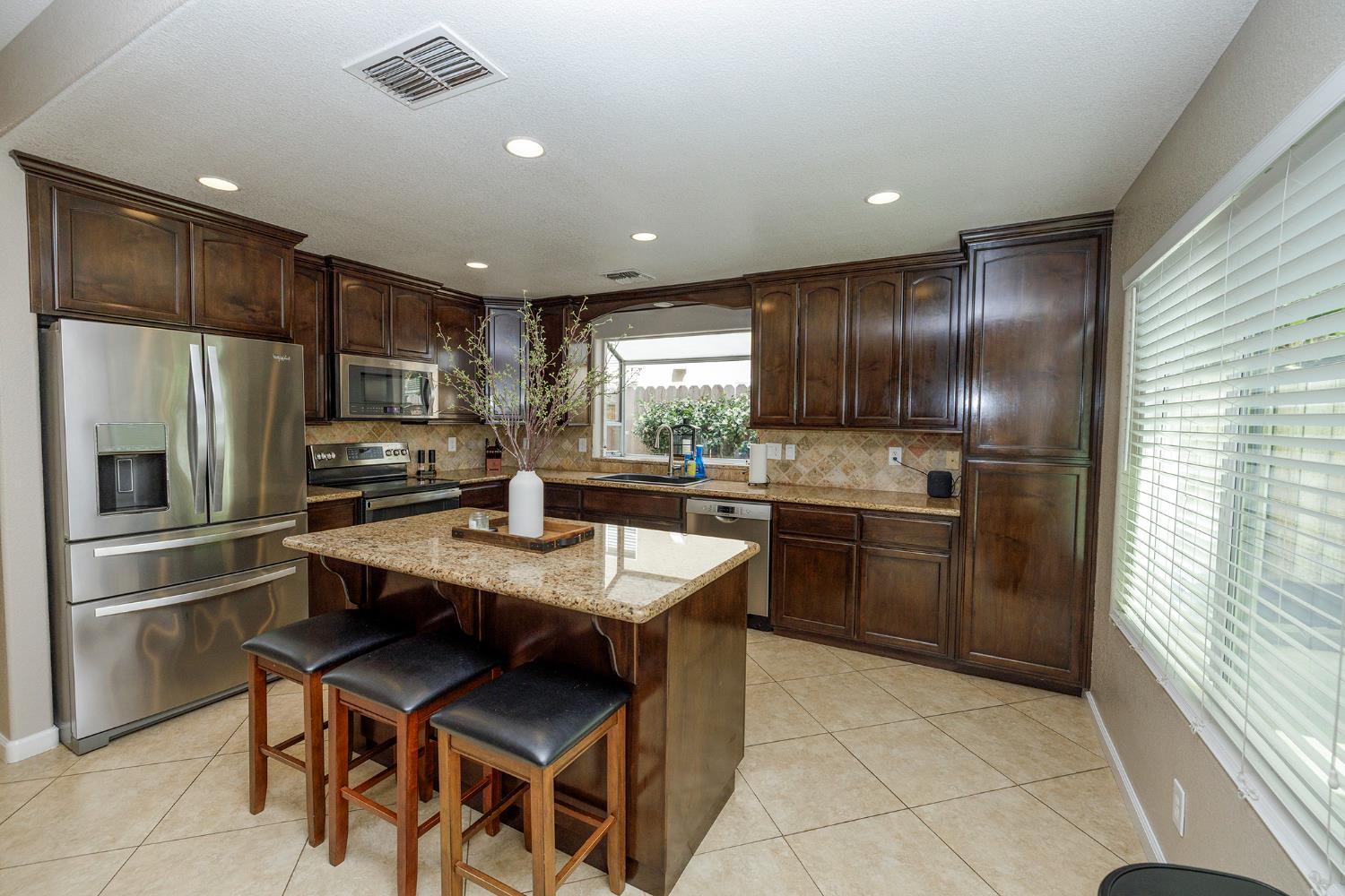 3416 Will Scarlet Way Modesto, CA 95355 - Photo 22 of 56 a kitchen with granite countertop stainless steel appliances and refrigerator