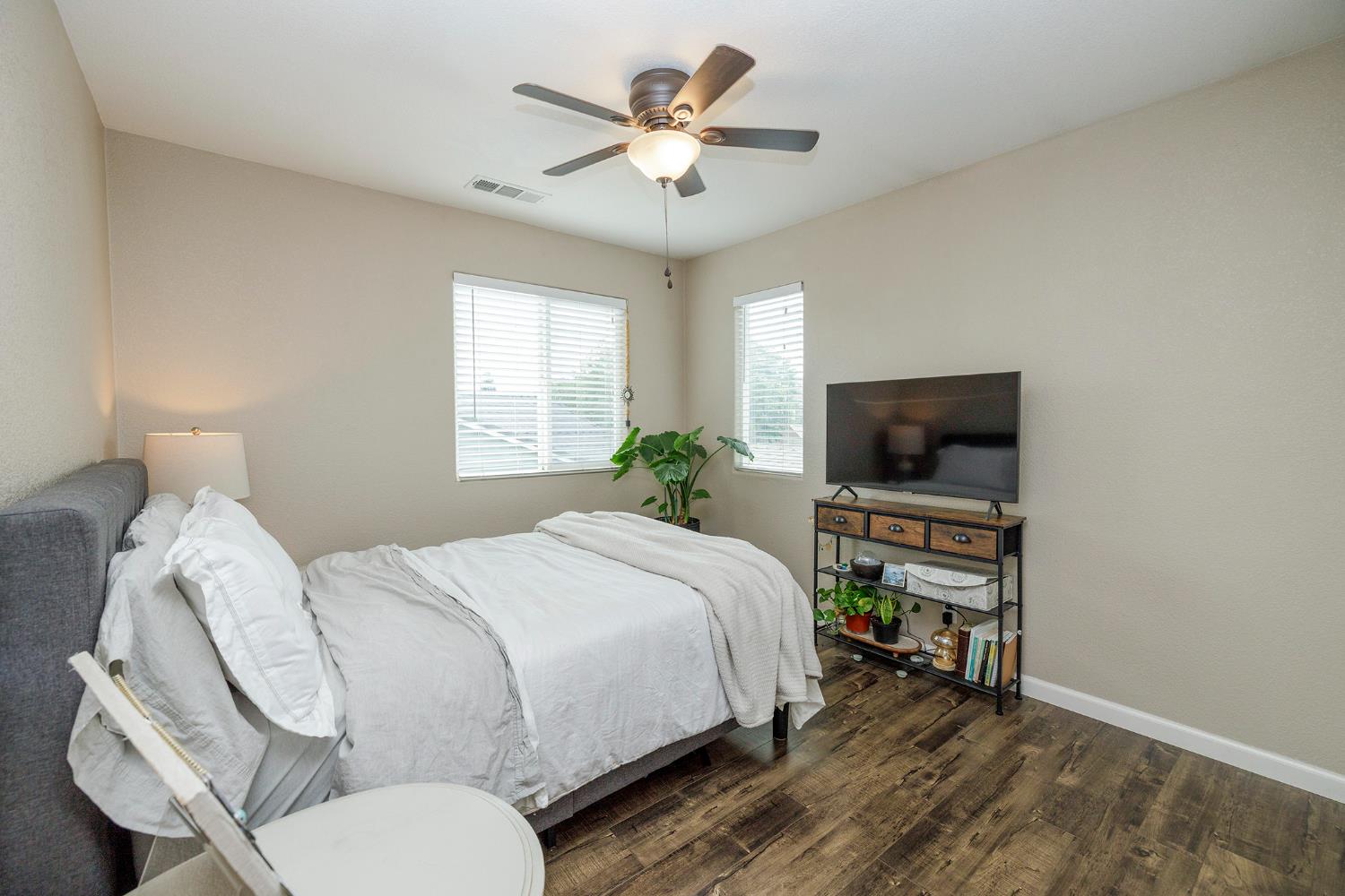 3416 Will Scarlet Way Modesto, CA 95355 - Photo 30 of 56 a bedroom with a bed a chandelier and a potted plant