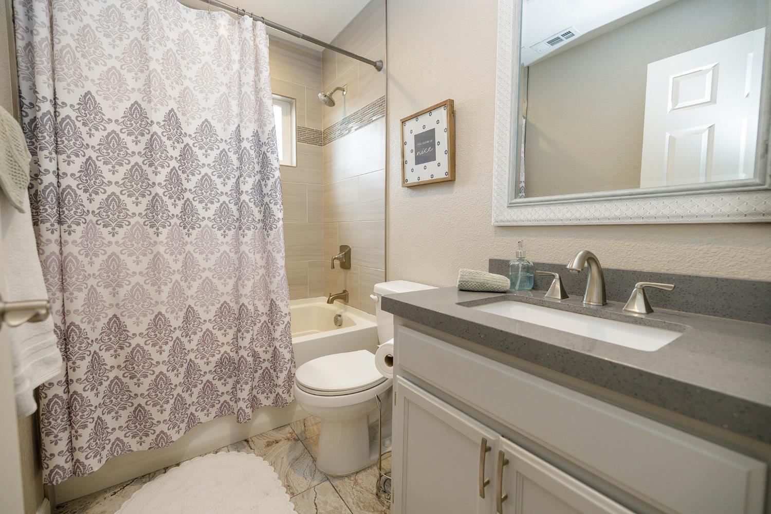 3416 Will Scarlet Way Modesto, CA 95355 - Photo 32 of 56 a bathroom with a granite countertop sink mirror vanity and toilet