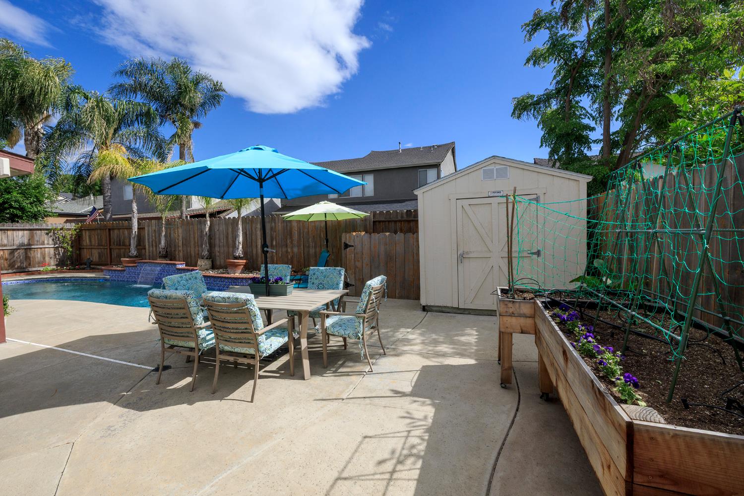 3416 Will Scarlet Way Modesto, CA 95355 - Photo 56 of 56 a view of a patio with a table and chairs under an umbrella