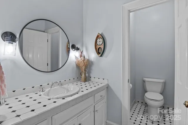 a bathroom with a sink a toilet and a mirror