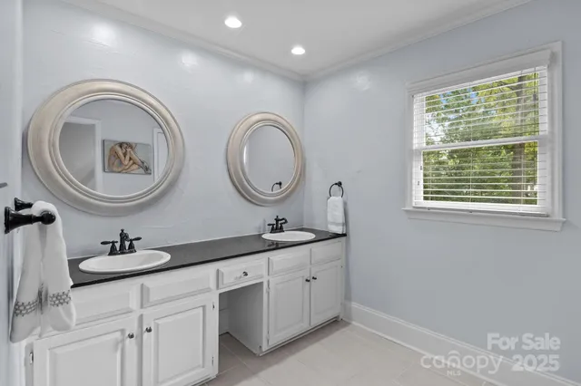 a bathroom with a granite countertop double vanity and a mirror