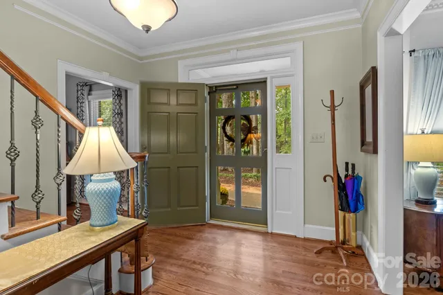 a view of a dining room with furniture a chandelier and wooden floor