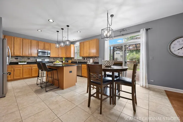 a kitchen with stainless steel appliances granite countertop a stove a sink a microwave oven and a dining table