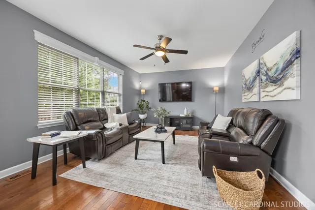 a living room with furniture ceiling fan and a window