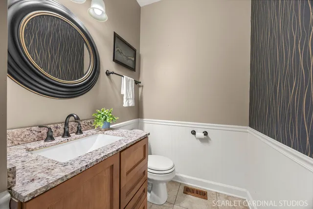 a bathroom with a granite countertop toilet sink and mirror