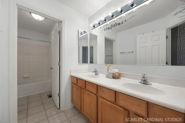 a bathroom with a double vanity sink a mirror and a shower