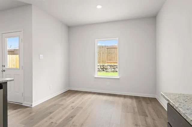 an empty room with wooden floor and a window