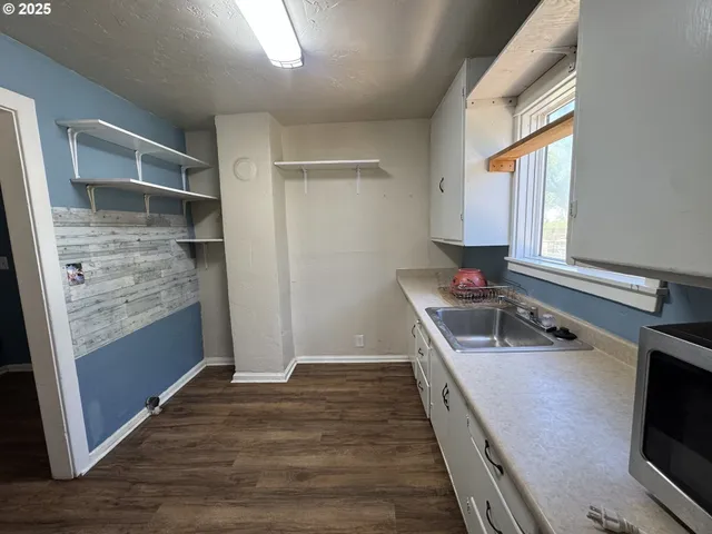 a kitchen with kitchen island granite countertop a sink stove and refrigerator