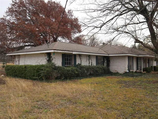 a view of a house with a yard and potted plants