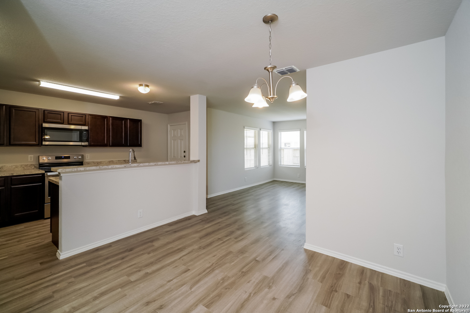 5122 Blue Ranch San Antonio, TX 78222 - Photo 7 of 16 a view of a kitchen with a sink and dishwasher a oven with wooden floor
