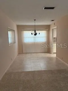 en empty room with windows and ceiling fan