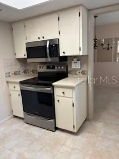a kitchen with stainless steel appliances white cabinets and a stove top oven