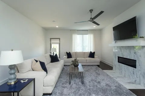 a living room with furniture a flat screen tv and a fireplace