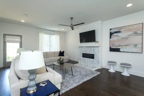 a living room with furniture a fireplace and a flat screen tv