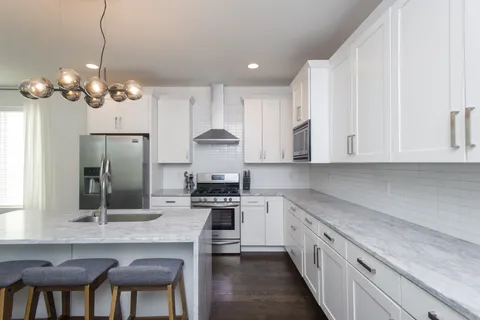 a kitchen with stainless steel appliances granite countertop a sink a stove a refrigerator and cabinets