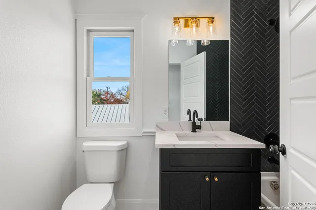 a bathroom with a sink a toilet and shower curtain