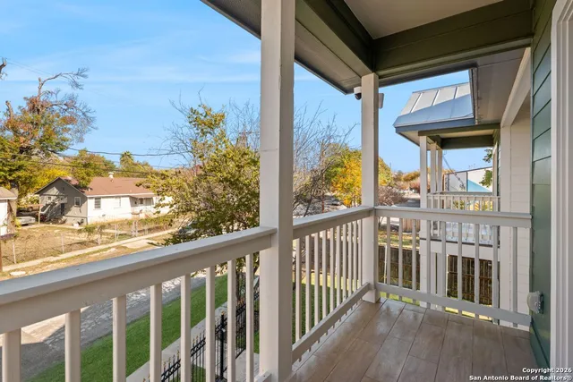a view of a balcony with wooden floor and fence