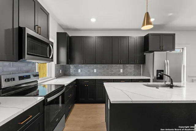 a kitchen with a sink a stove and refrigerator