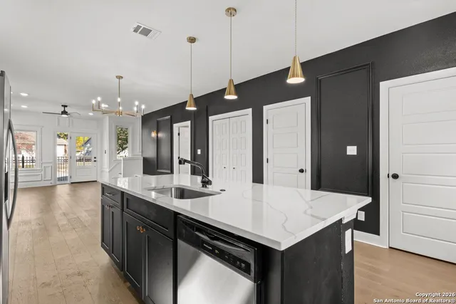 a kitchen with a counter top space a sink appliances and cabinets