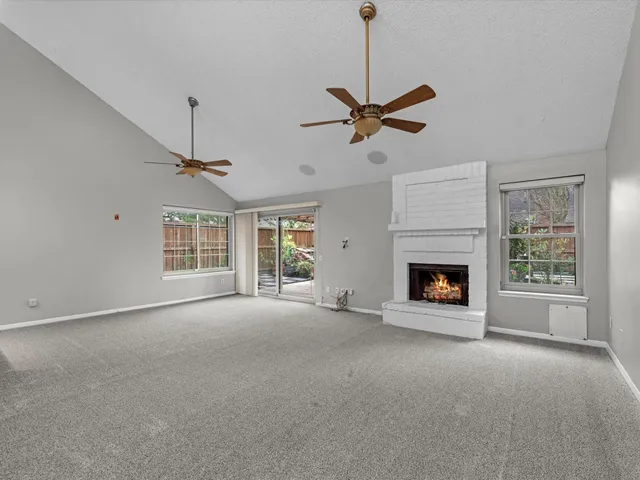 a view of empty room with fireplace and windows