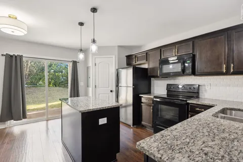 a kitchen with stainless steel appliances granite countertop a sink stove and refrigerator